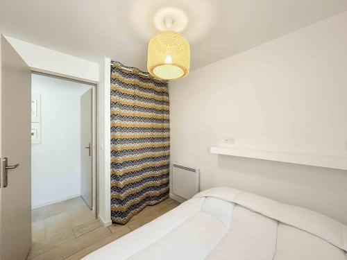 une chambre avec un lit et un mur avec une couverture dans l'établissement T2 - accès plage - balcon et parking privé, à Sanary-sur-Mer