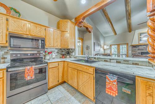 a large kitchen with wooden cabinets and stainless steel appliances at Near Hiking Trails Spacious Cloudcroft Retreat! in Cloudcroft