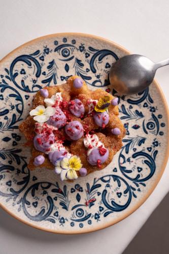 a blue and white plate with a spoon and some food at CoolRooms Palacio de Atocha in Madrid