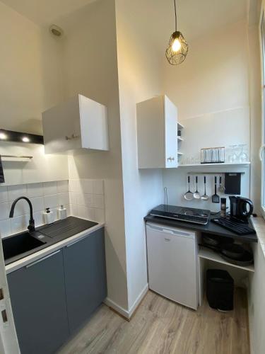 une petite cuisine avec des armoires blanches et un évier dans l'établissement Charmant T2 - Centre - 4 personnes, à Angers
