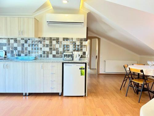 a kitchen with a white refrigerator and a table at Centrally Located Very Large Villa W Pool Jakuz and Car Park in Fethiye