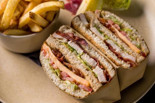 a sandwich and a bowl of french fries on a plate at Maison Albar - Amoure in Braga