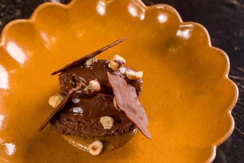 a chocolate dessert with nuts on top of it at Maison Albar - Amoure in Braga
