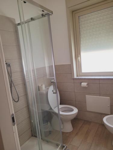 a bathroom with a toilet and a glass shower at HOUSE AIRPORT Catania 2 in CTA