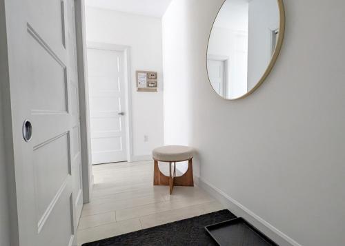a hallway with a round mirror and a stool at La vie est belle: FREE PARKING, GYM, ROOFTOP TERRACE in Quebec City