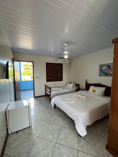 a bedroom with two beds and a ceiling at RESTAURANTE POUSADA E ESCUNA RIO SOl in São João da Barra