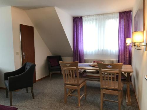 a dining room with a table and chairs and a window at Landhaus Heidekrug in Hildesheim
