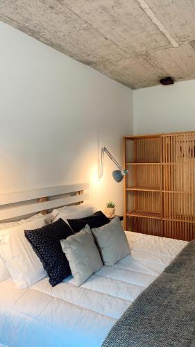 a bedroom with a large white bed with pillows at Láurea Ecocasona in Oreña