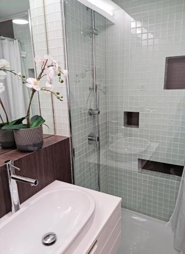 a bathroom with a sink and a shower with a glass door at Lagos Factory Yellow by Marina with AC in Lagos