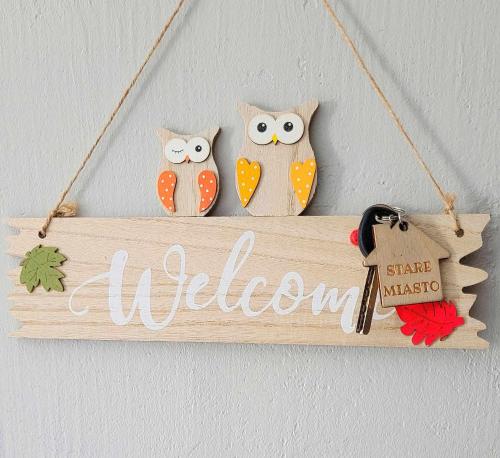 two owls and a welcome sign hanging on a wall at STARE MiASTO II in Olsztyn