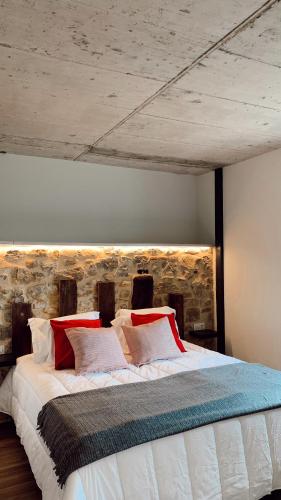 a bedroom with a large bed with red pillows at Láurea Ecocasona in Oreña