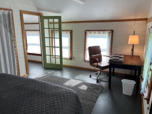 a bedroom with a bed and a desk and a chair at Relax Like It's 1800! in Pond Eddy