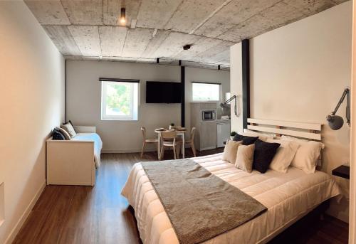 a bedroom with a large bed and a table at Láurea Ecocasona in Oreña