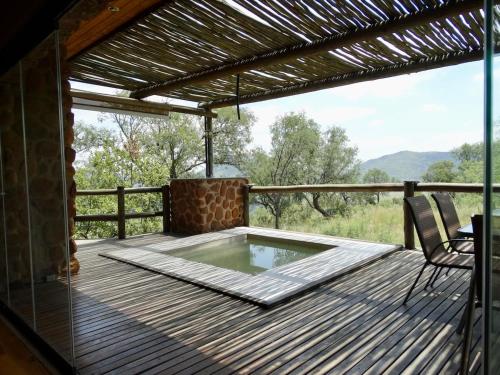 Un patio con jacuzzi en una terraza de madera. en Forestiva Farm - Mountain Retreat, en Centurion