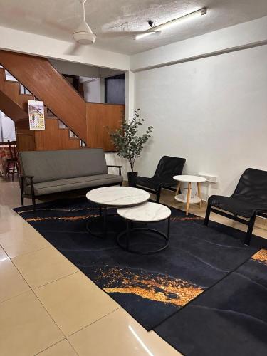 a room with two tables and a couch and chairs at The Majestic Home Ampang in Kuala Lumpur