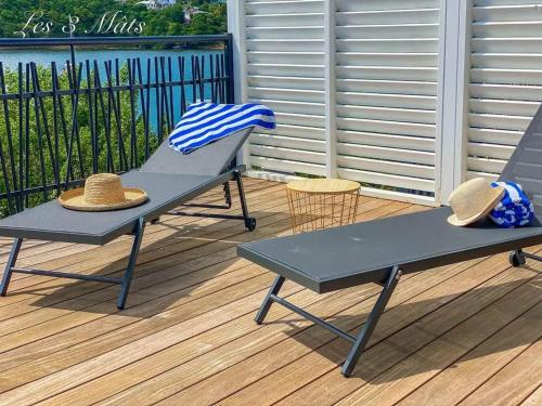 two picnic tables on a deck with hats on them at Villa confortable avec piscine à Hyacinthe – 95 m² in Hyacinthe