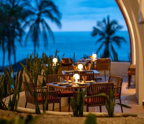 a restaurant on the beach with tables and chairs at Condos Privados en Huatulco in Tangolunda