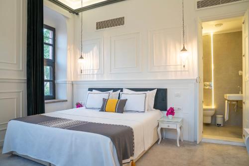 a bedroom with a large white bed with pillows at Siyah Lale Cunda 1841 in Cunda
