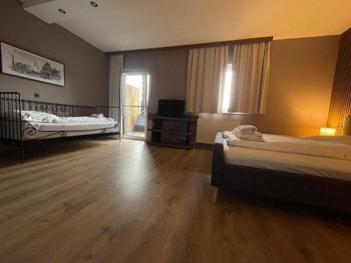 a large room with two beds and a window at The Art and Sporthotel in Innsbruck