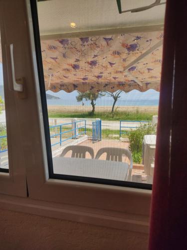 una finestra con vista su un tavolo e sedie. di Sand house 2 a Néa Péramos