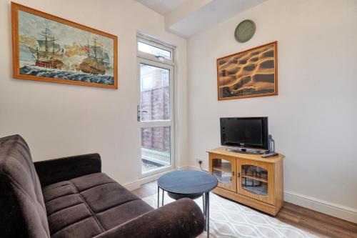 a living room with a couch and a tv at Ivy on Sea Villa in Southend-on-Sea