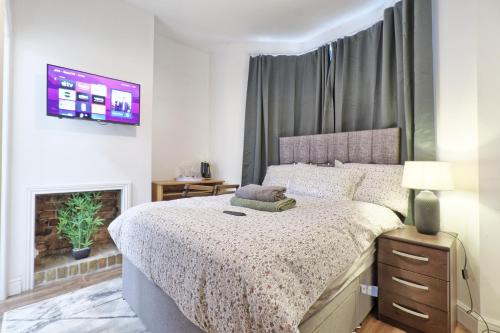 a bedroom with a large bed and a fireplace at Ivy on Sea Villa in Southend-on-Sea