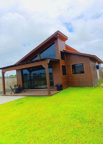 サン・フランシスコ・ド・スルにあるCasa de Praiaの芝生の上に広いデッキがある家