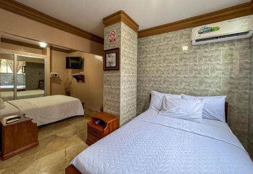 a bedroom with two beds and a bathroom at Hotel Bucaneiro in Manta
