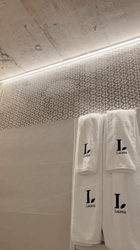 three white towels are lined up on a wall at Láurea Ecocasona in Oreña