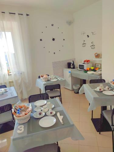 a dining room with tables and chairs with food on them at F.A.M. ROOMS in Ciampino