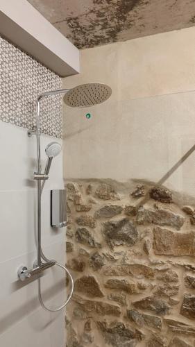 a shower in a bathroom with a stone wall at Láurea Ecocasona in Oreña