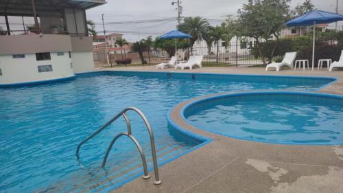 a large swimming pool with blue water in a building at Escápate a Manta Piscina y Confort in Manta