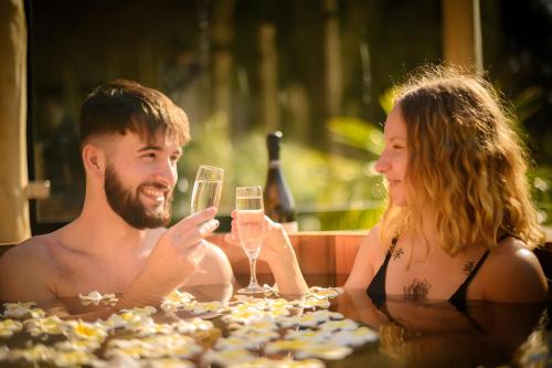 un homme et une femme assis à une table avec des verres de vin dans l'établissement La Cabane Java, à Angoisse