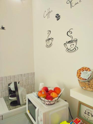 a bowl of fruit sitting on top of a microwave at F.A.M. ROOMS in Ciampino