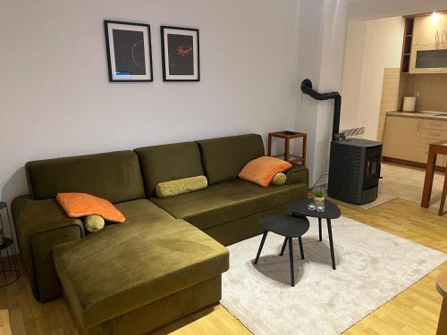 a living room with a green couch and a table at Kupres Apartman555 in Kupres