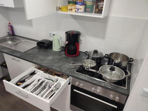 a kitchen counter with a stove with pots and pans at Ferienhaus Stani in Eschwege