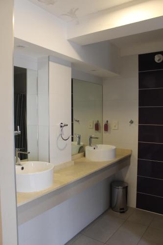 a bathroom with two sinks and a large mirror at Nómade Hostel mdz in Mendoza