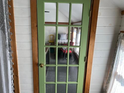 a green door with a glass window on a house at Relax Like It's 1800! in Pond Eddy
