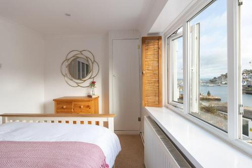 a bedroom with a bed and a large window at Oyster Catcher Cottage - Harbour Bowl, Sea Views in Brixham