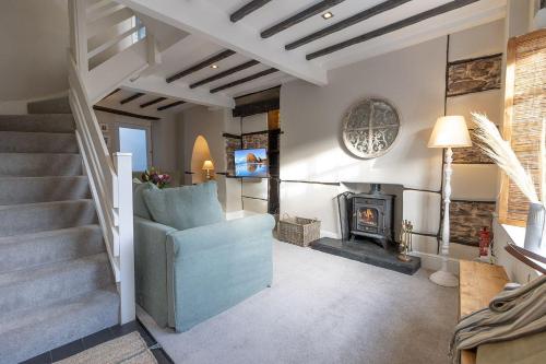 a living room with a staircase and a fireplace at Oyster Catcher Cottage - Harbour Bowl, Sea Views in Brixham
