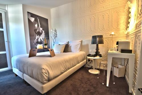 a bedroom with a king sized bed and a desk at Hôtel des Beaux-Arts Toulouse in Toulouse