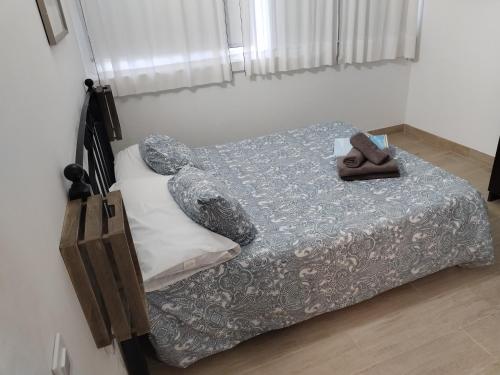 a bedroom with a bed with a pair of slippers on it at Apartamento Sol B Free Parking in Vecindario