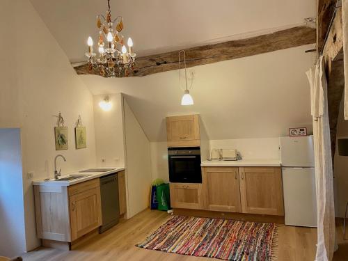 a kitchen with wooden cabinets and a chandelier at Chez TESS in Saint-Félix