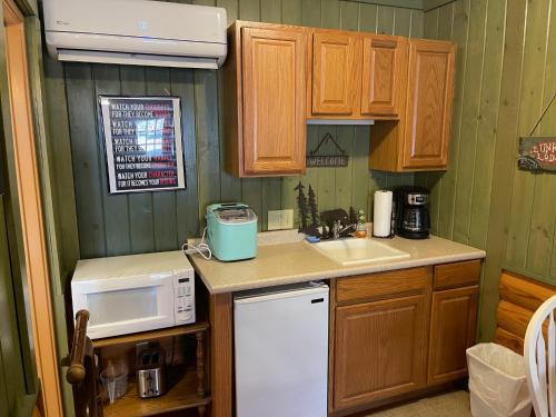 a kitchen with a white refrigerator and a sink at Mountain Aire Cottages, Inn, & Glamping in Clayton