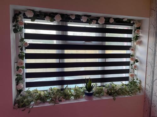 a window with plants on a window sill at Secret garden in Ferndown