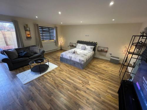 a living room with a bed and a couch at Secret garden in Ferndown