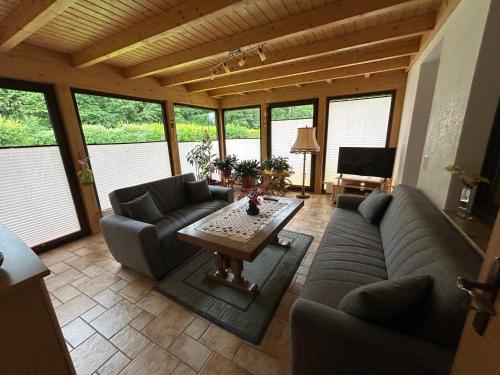 a living room with couches and a table at Gerds Gartenwohnung in Ottrau