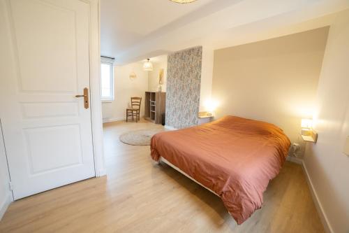 Un dormitorio con una cama y una habitación con una puerta. en L 'écrin Vert, en Breteuil