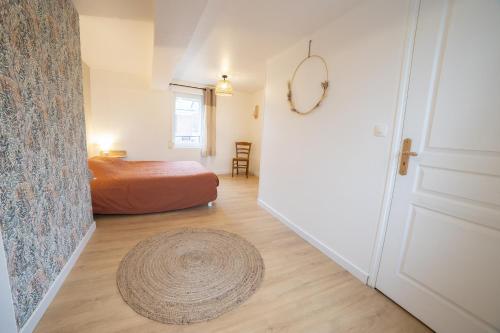 1 dormitorio con cama, puerta y alfombra en L 'écrin Vert, en Breteuil