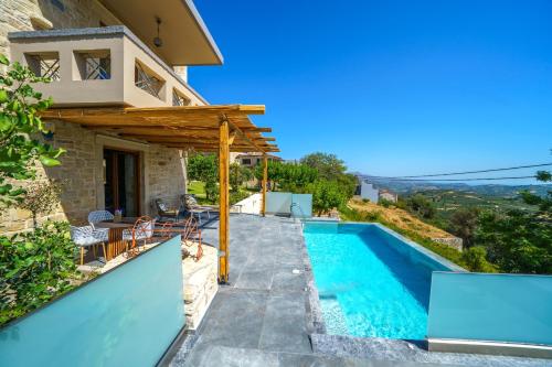 a villa with a swimming pool and a house at Asion Lithos in Kato Asites